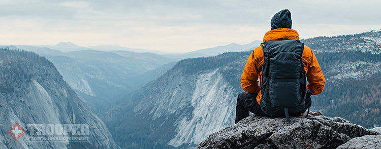 Wanderer sitzt auf Felsen und geniesst Aussicht