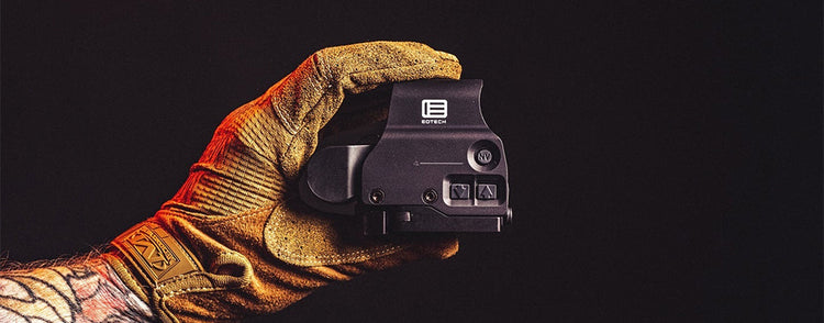 Hand mit Schutzhandschuh hält ein holographisches Visier von EOTech